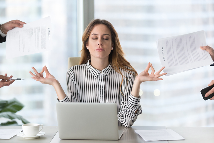 Calm female manager meditating taking break avoiding stressful job